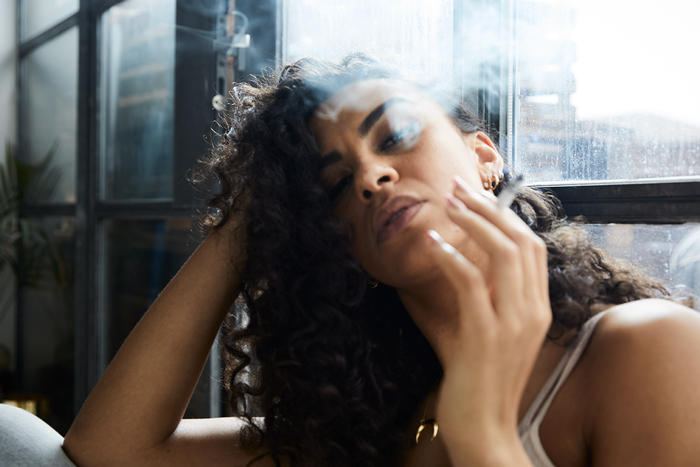 Woman blowing smoke into camera